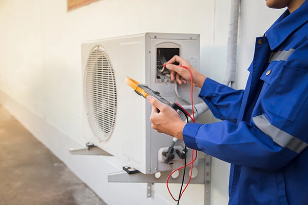 HVAC service technician using gauges to check refrigerant and add refrigerant