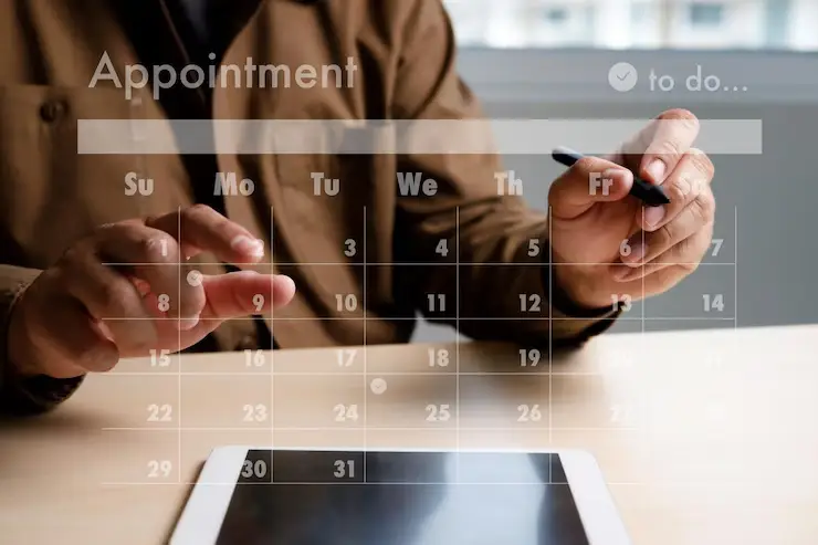 midsection-man-using-mobile-phone_1048944-9124873 A person is using a stylus on a tablet with a digital calendar overlay, planning appointments for the week ahead.